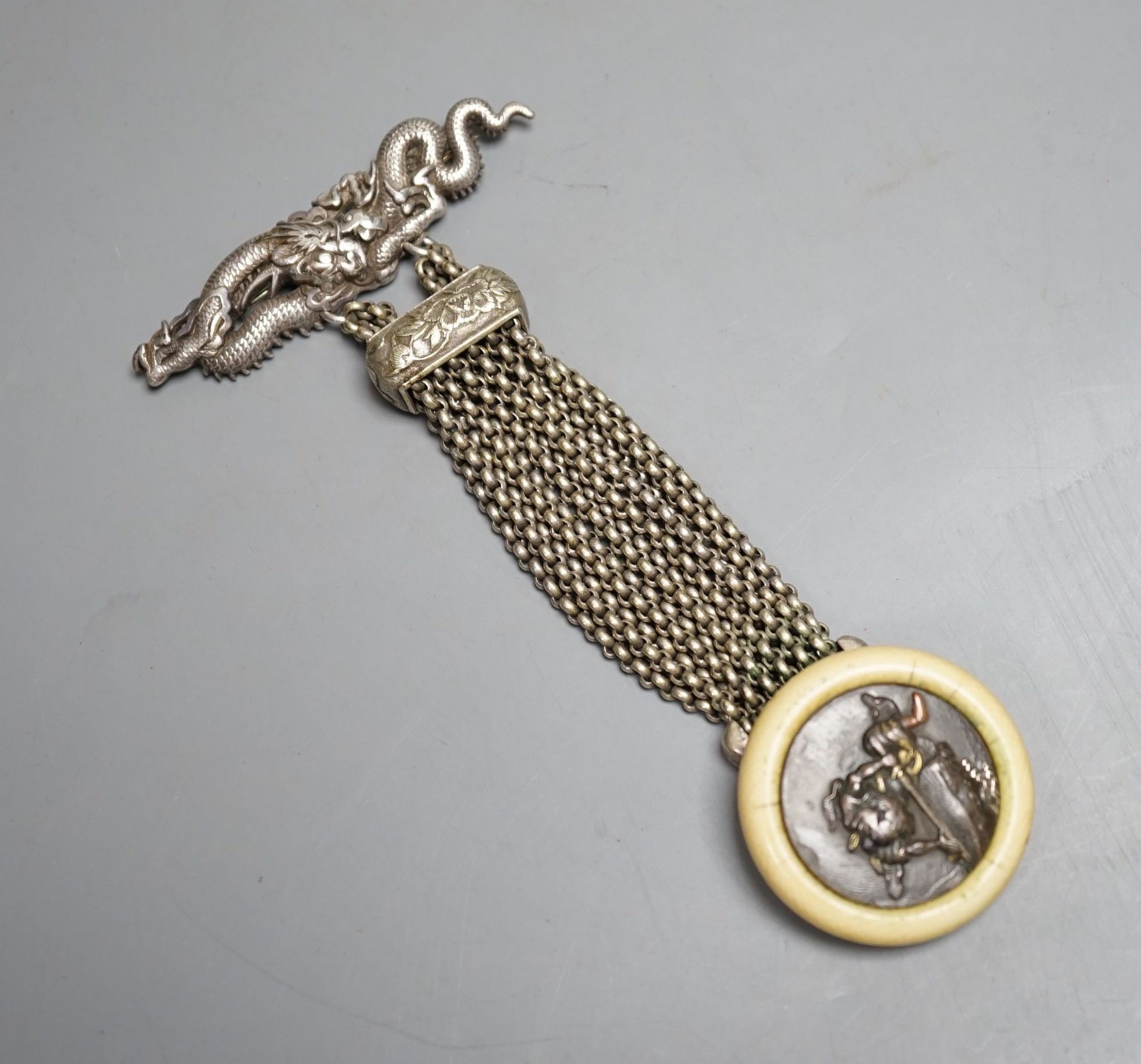 A Japanese ivory Manju netsuke with white metal and base metal suspension brooch